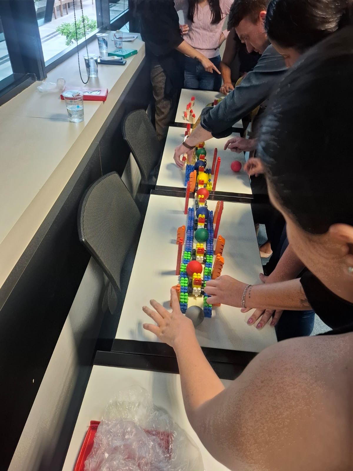 Equipe construindo desafio colaborativo com peças coloridas